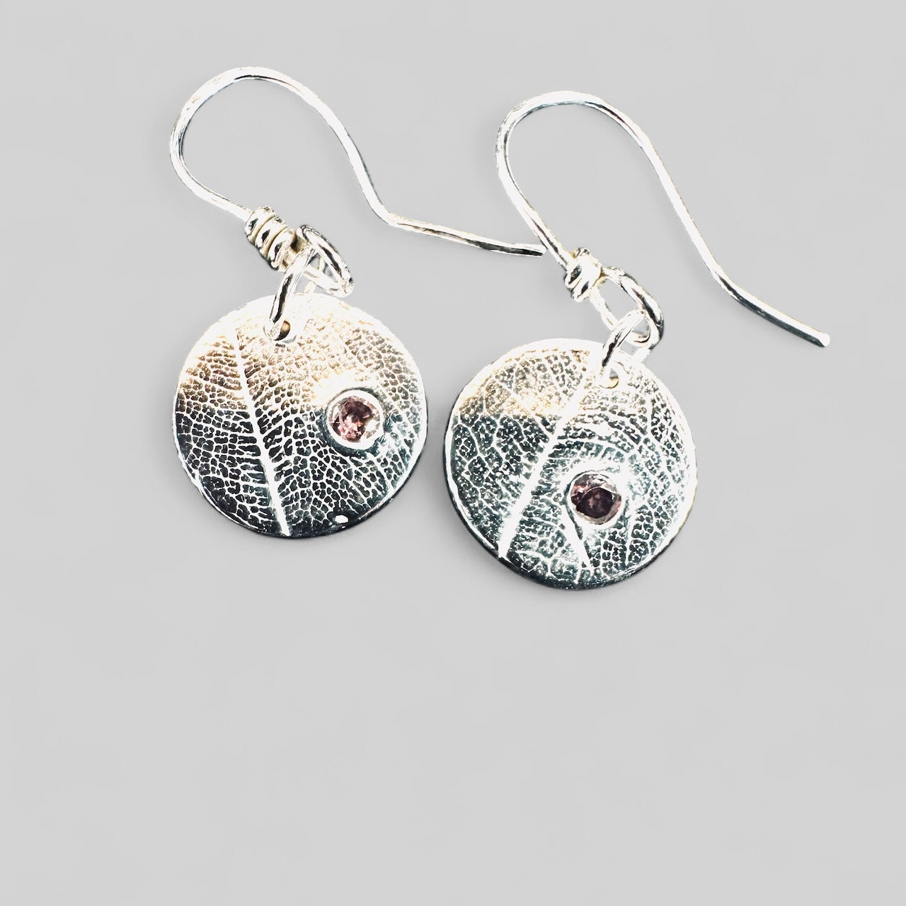 Artisan Hancrafted sustainable Bespoke Fine Silver disc leaf textured earrings with cubic Zirconia red gemstone valentines birthday anniversary gift only one pair available.