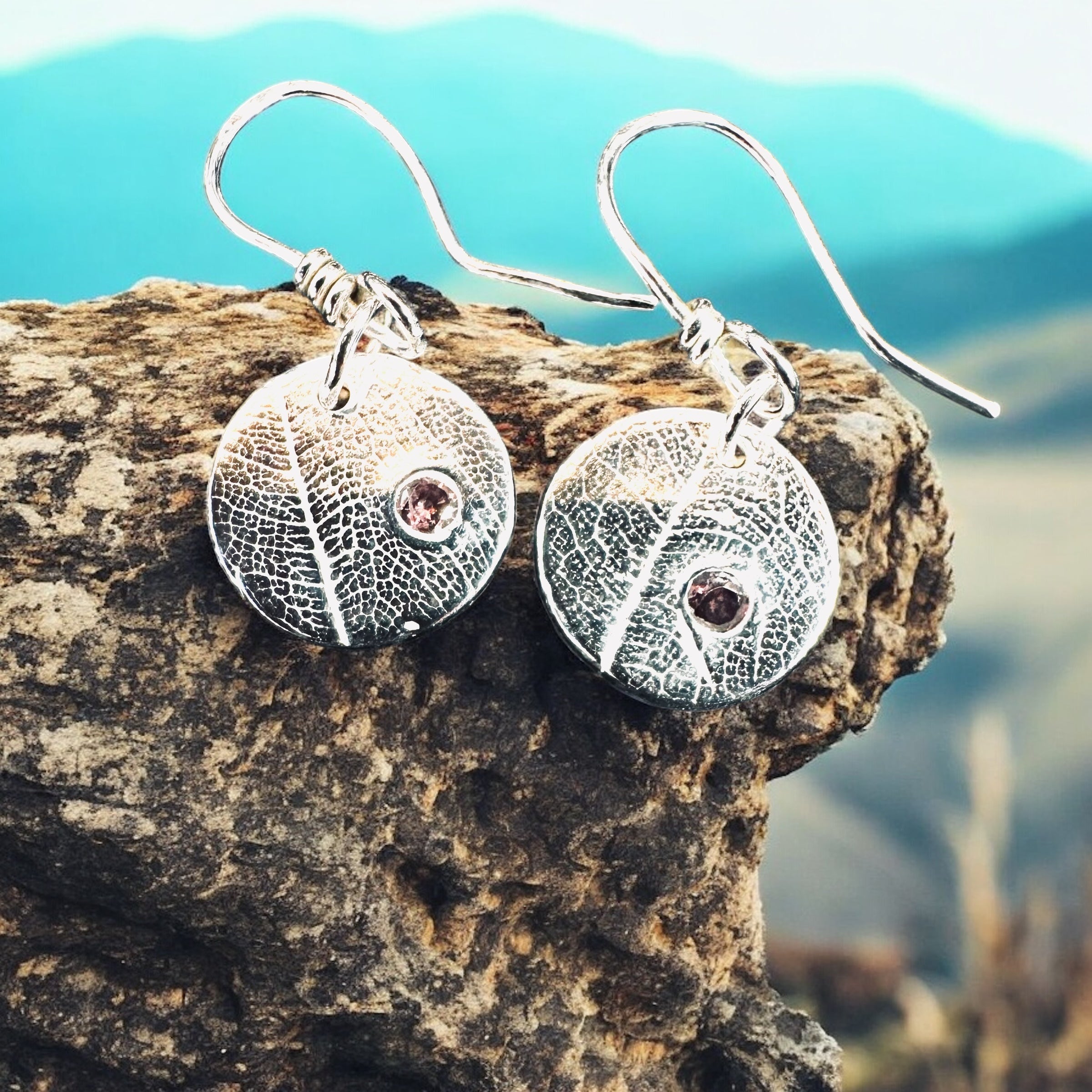 Artisan Hancrafted sustainable Bespoke Fine Silver disc leaf textured earrings with cubic Zirconia red gemstone valentines birthday anniversary gift only one pair available.